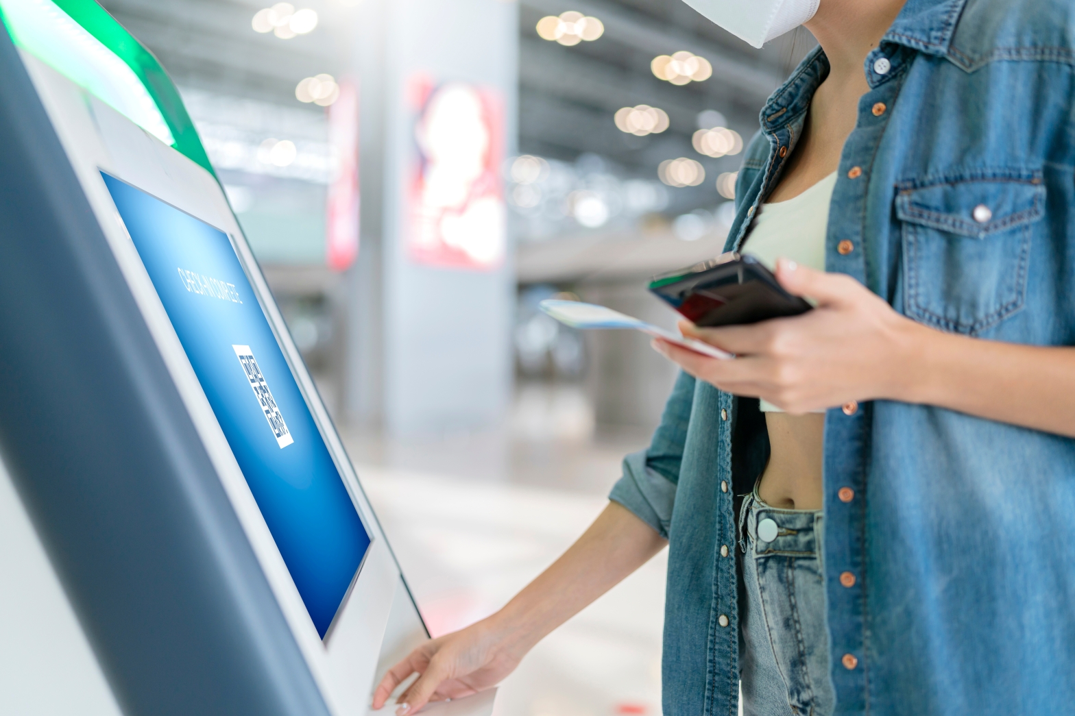 Woman uses a contactless checkin terminal at airport